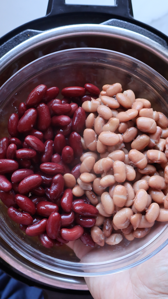 adding kidney beans and pinto beans to the mashawa after it is pressure cooked fully.